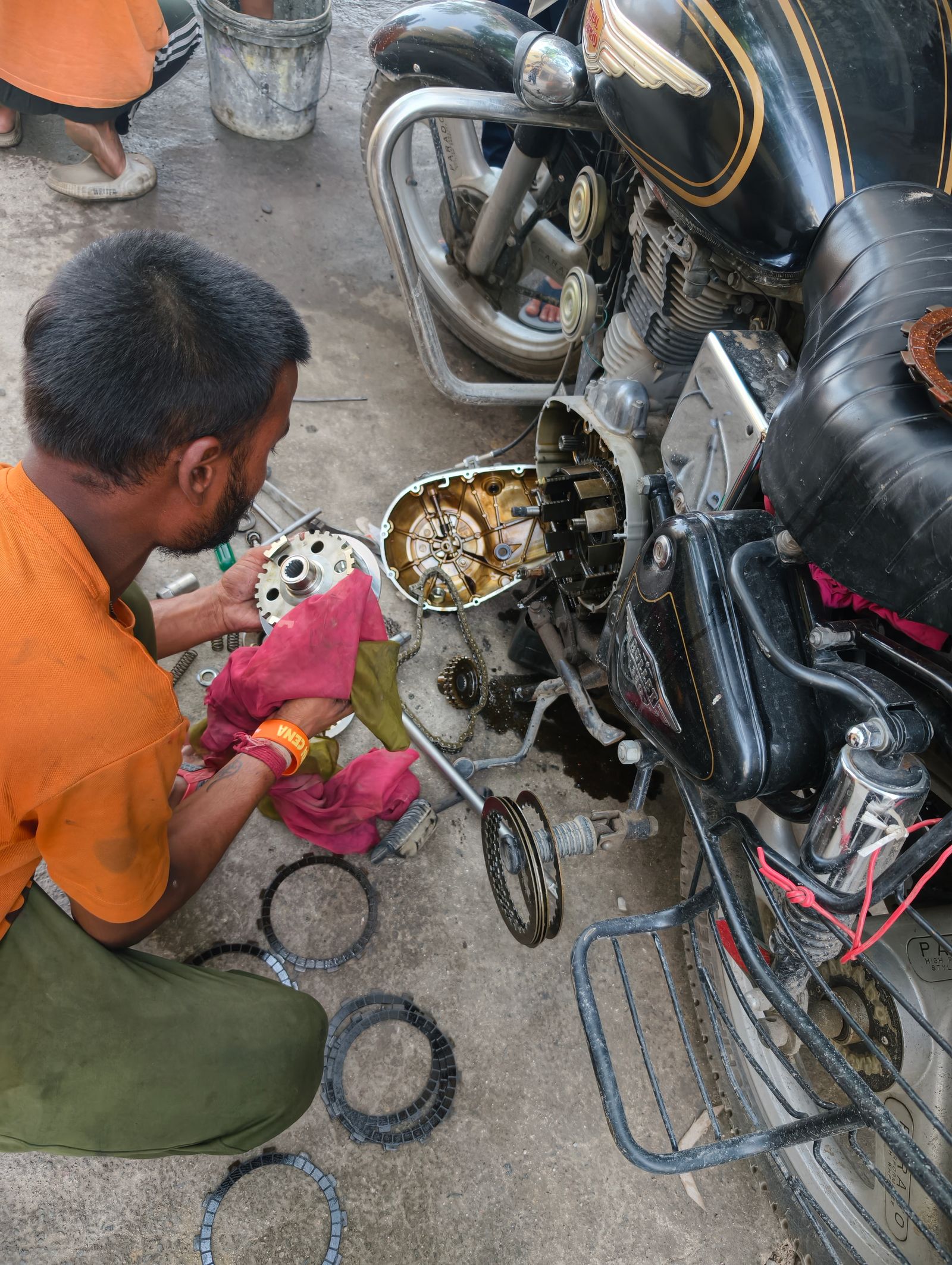 Mécanicien travaillant sur les pièces du moteur d'une moto en extérieur