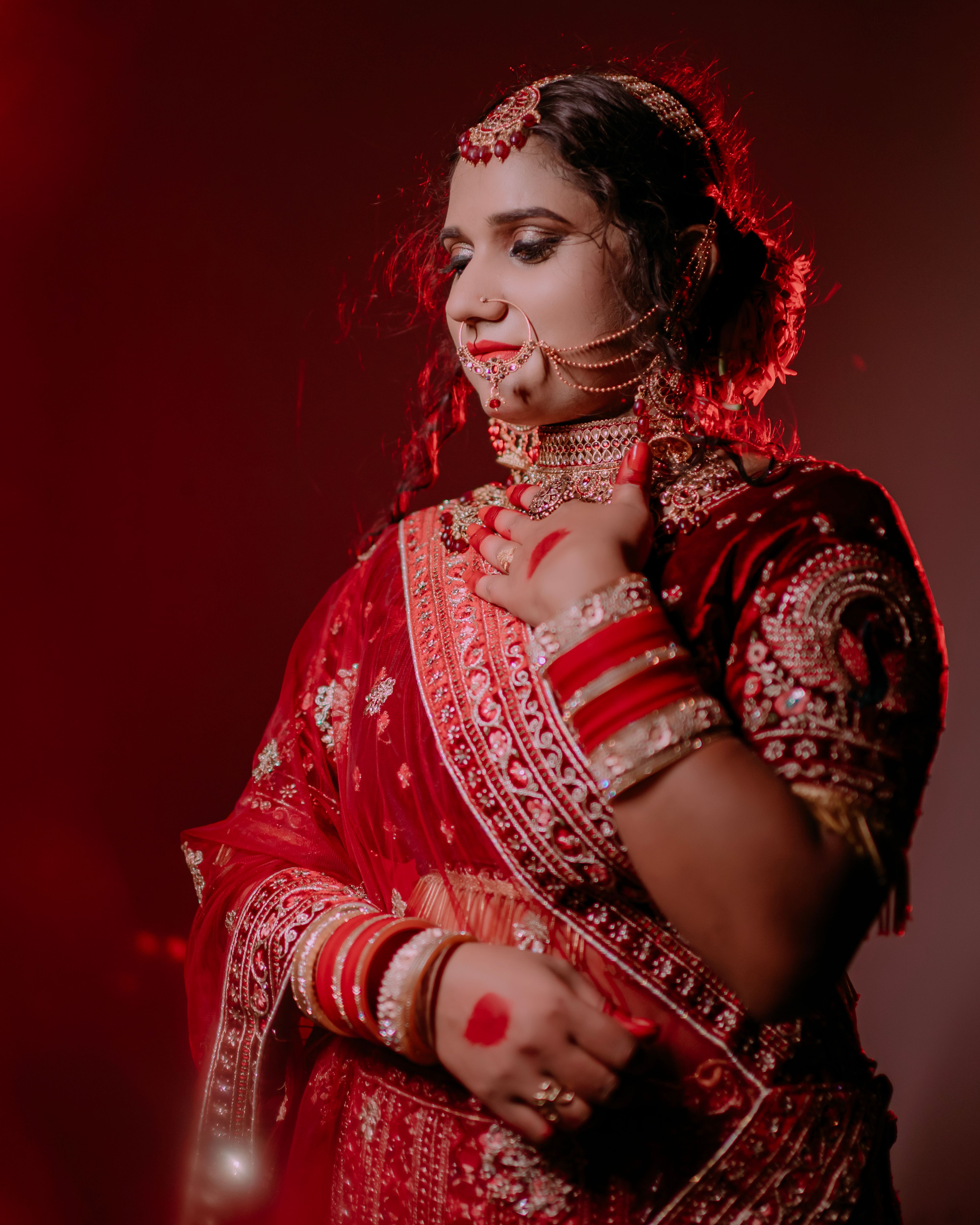 A beautiful portrait of a bride wearing traditional red attire, adorned with gold jewelry.