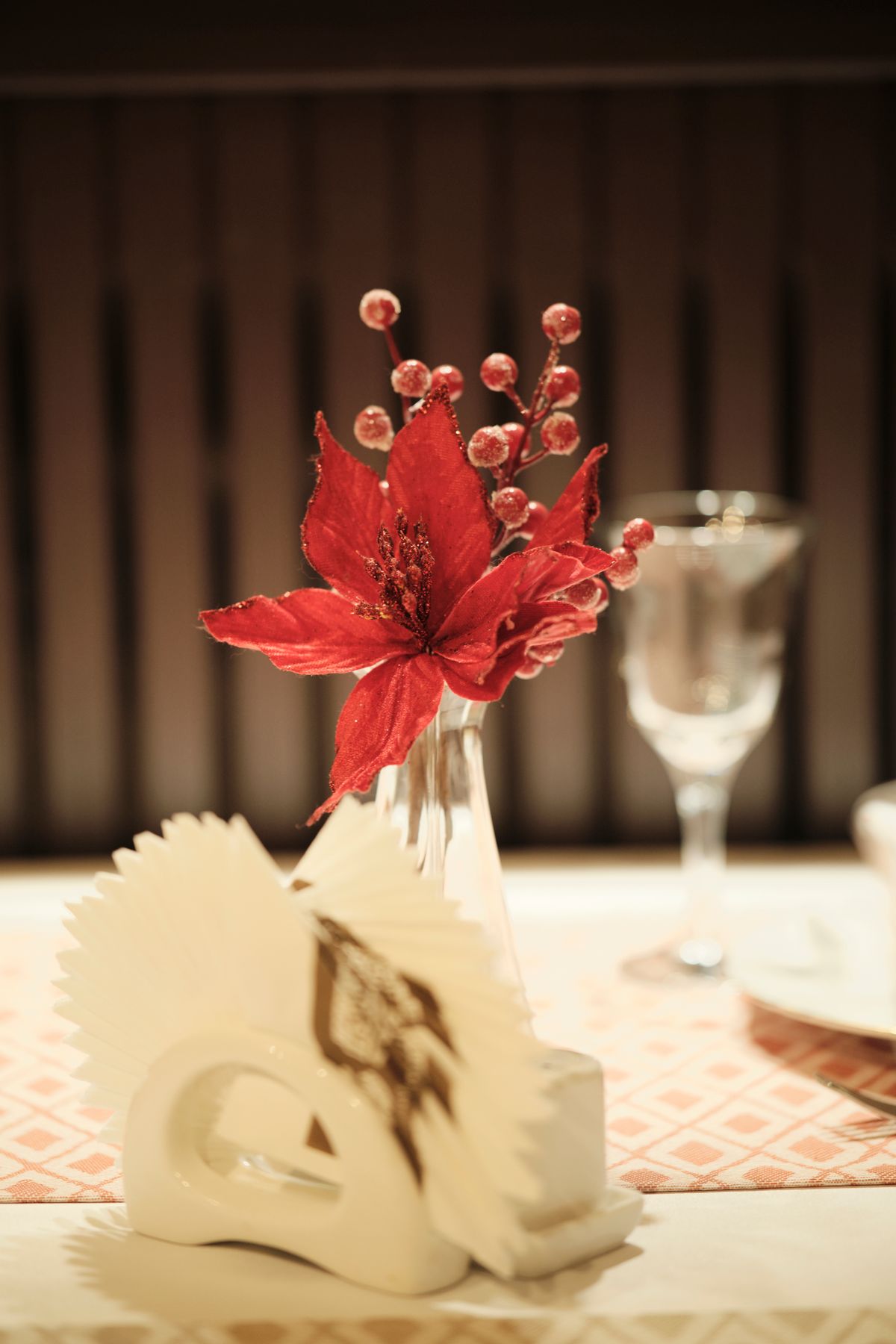 Red poinsettia-style folded napkin at the centre of a festive table setting