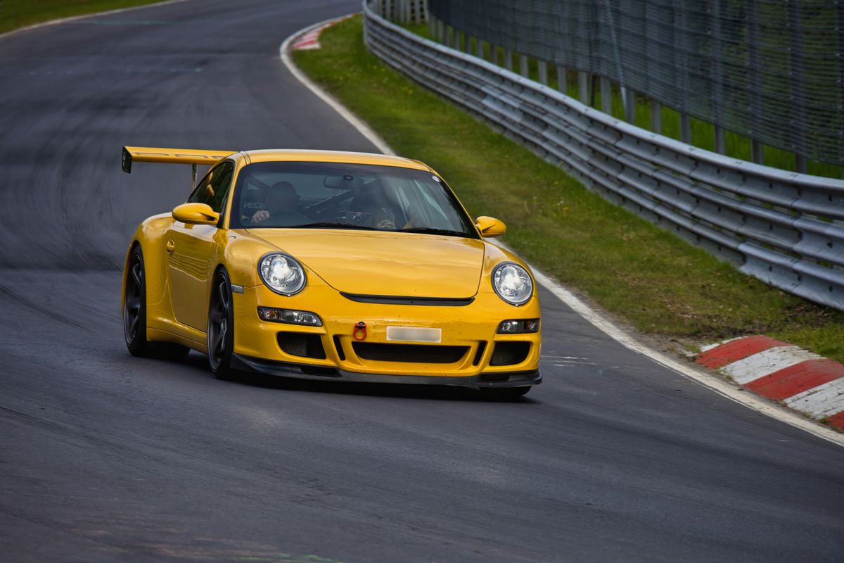 Porsche galben cu aripa mare langa parapet