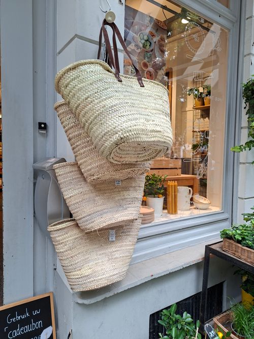 Free Charming display of woven straw bags at a Bruges shop entrance, inviting eco-friendly shopping. Stock Photo