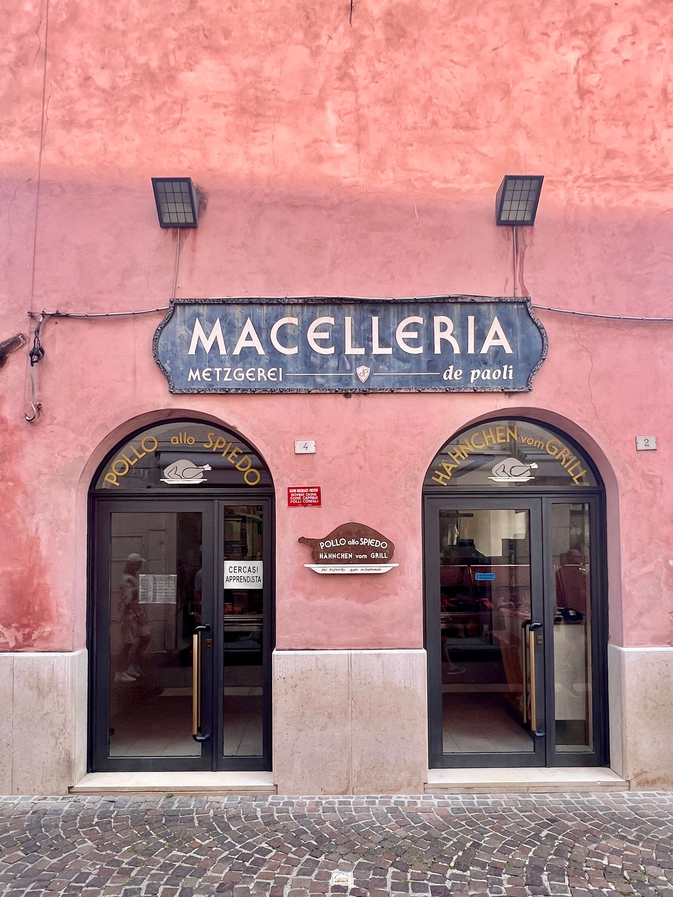Front view of an Italian butcher shop with classic architectural elements in a historic town.