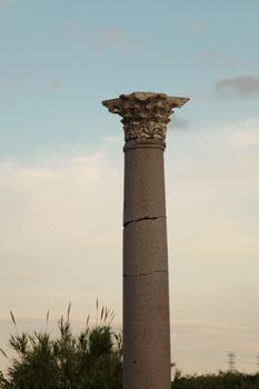 A solitary ancient column in Antalya, Türkiye, symbolizing historical grandeur against a serene sky.