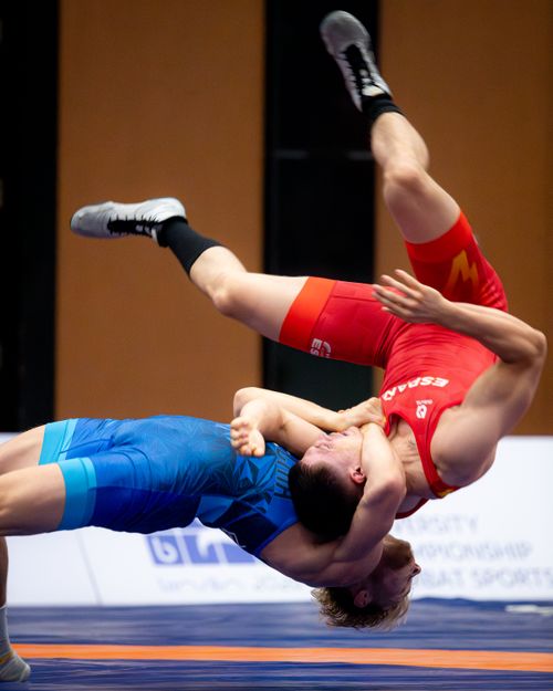 Free Two wrestlers engaged in an intense freestyle wrestling match, showcasing athleticism and technique. Stock Photo