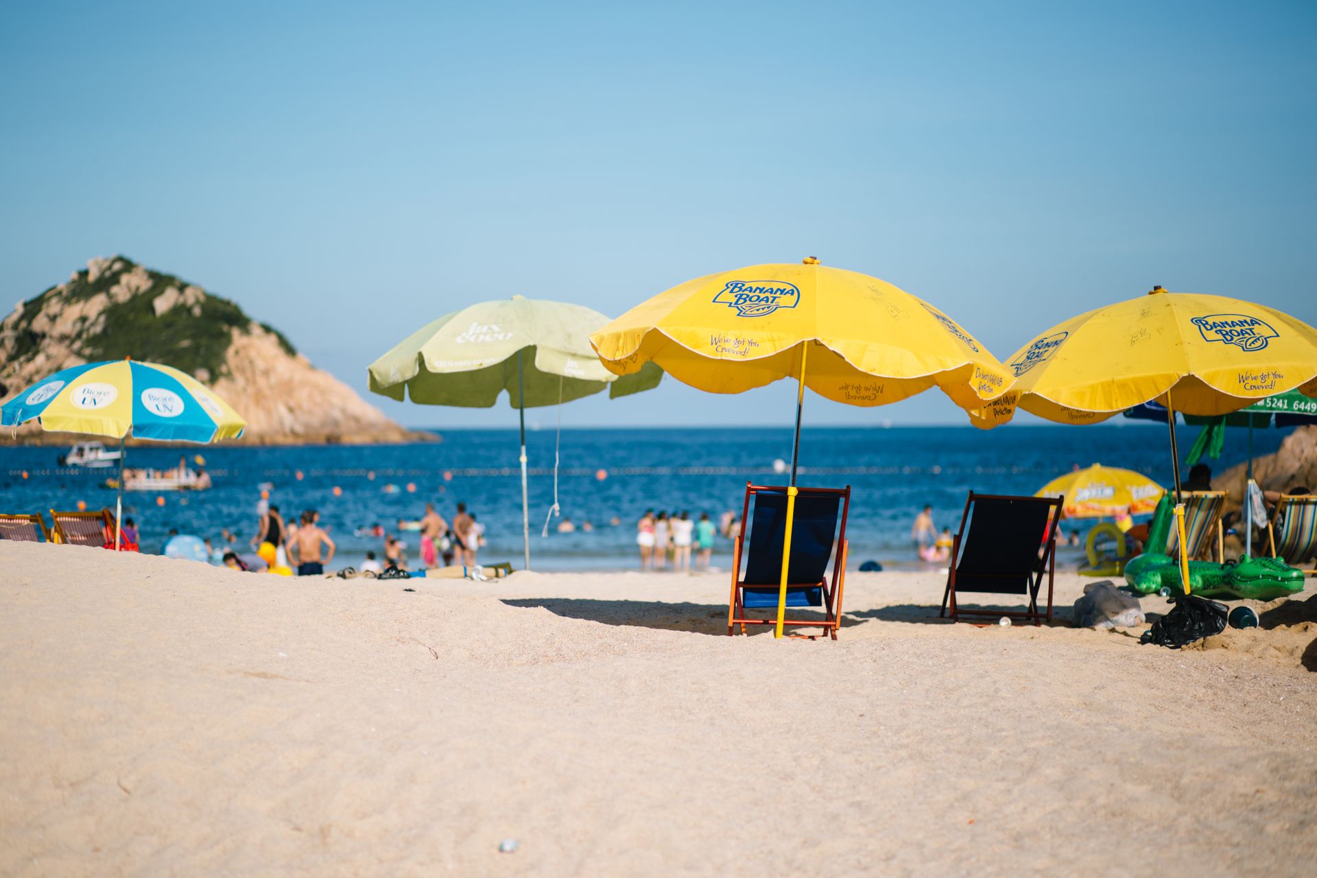 Photo of Folding Chairs and Umbrellas on Beach