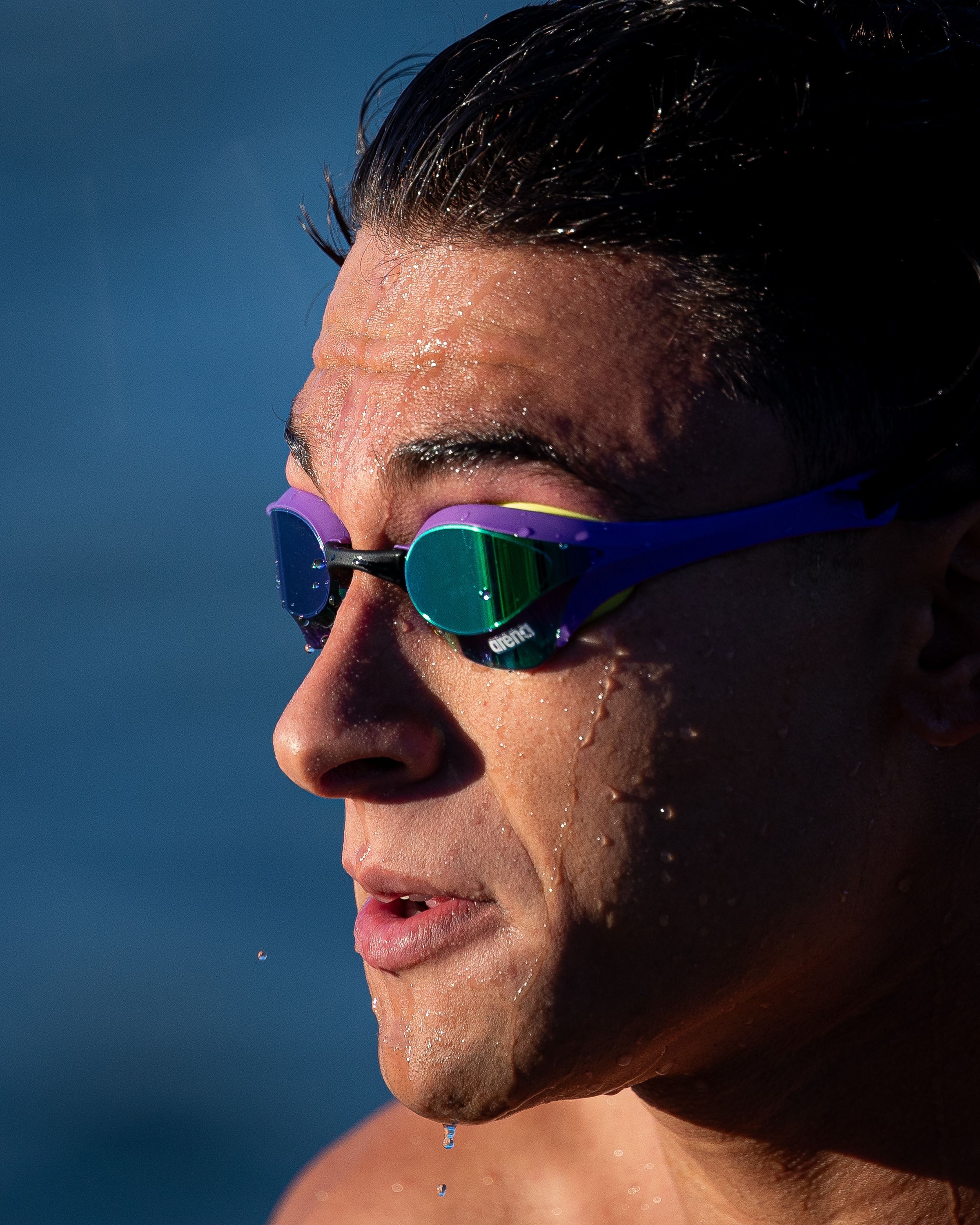 Close-up of a swimmer wearing goggles, emerging from water in Brazil during daylight.