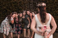 Cheerful multiethnic bridesmaids waiting for flower bouquet from unrecognizable bride