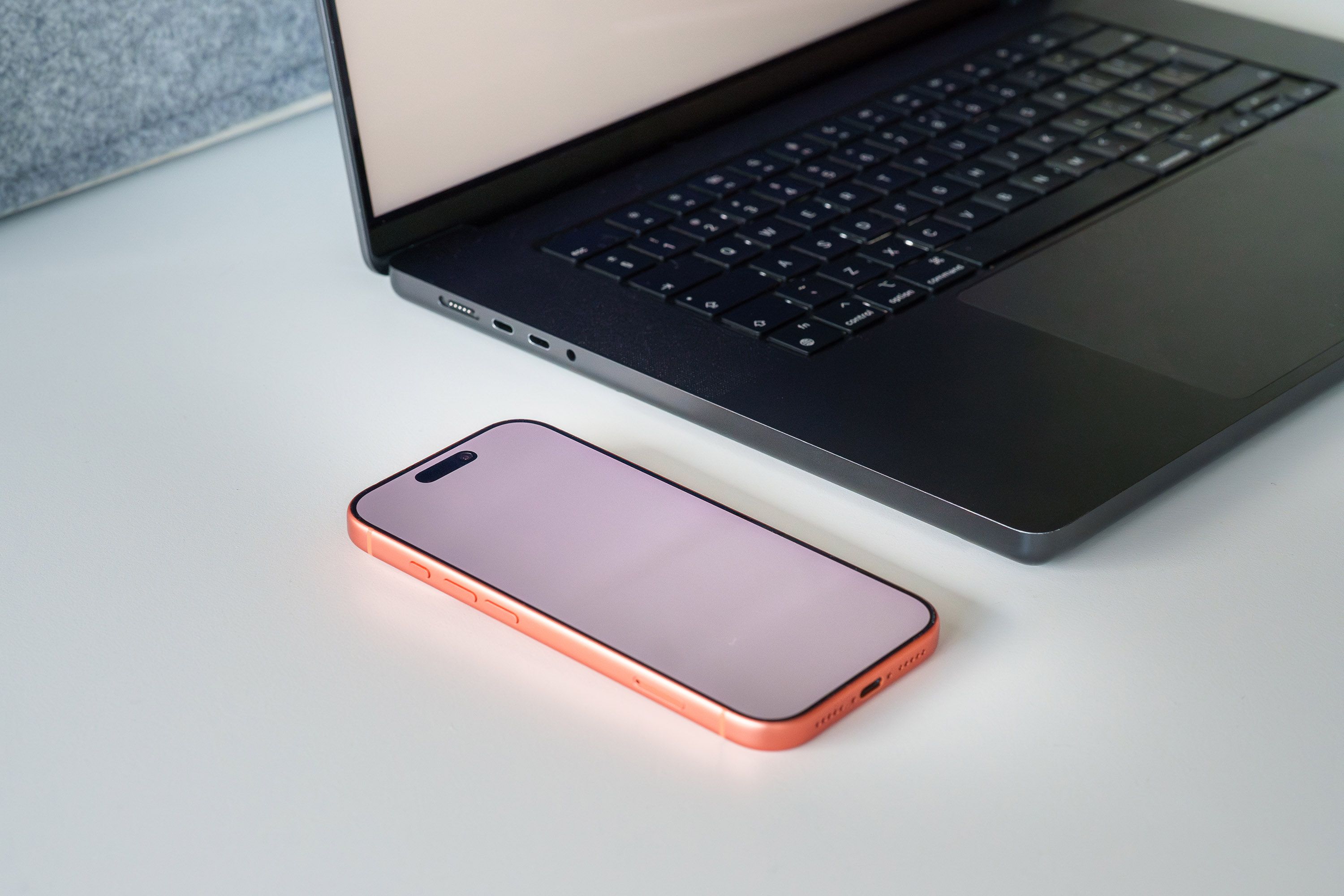 minimalist desk setup with one laptop, one phone, and a notebook — no clutter