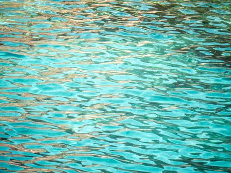 Serene image of turquoise water ripples reflecting sunlight, perfect for relaxation themes.