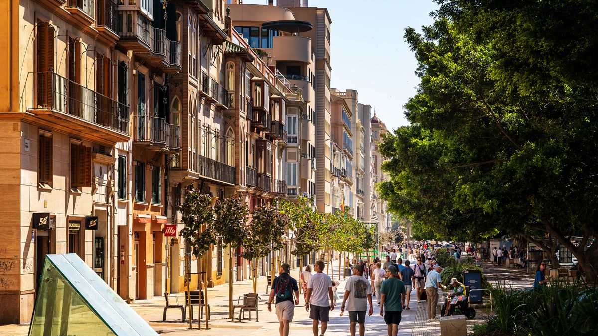 A bustling European street with pedestrians and classic architecture under the summer sun.