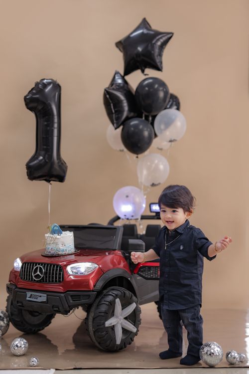 Free A toddler celebrating their first birthday with balloons and a toy car. Stock Photo