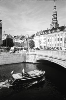 Black and white photo of a boat on a canal in historic Malmö City, Sweden.