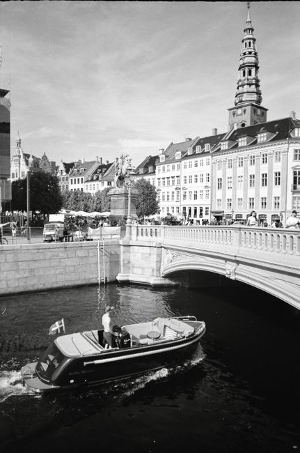 Black and white photo of a boat on a canal in historic Malmö City, Sweden.