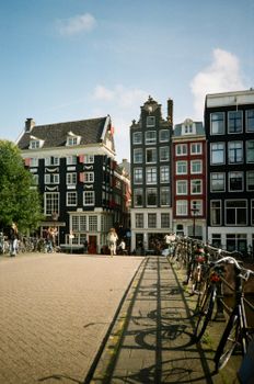 Picturesque view of Amsterdam's iconic canal houses and bicycles on a sunny day.