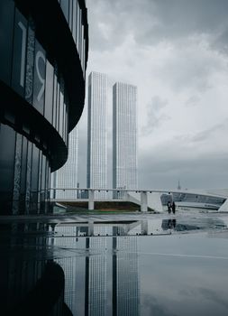 Two tall skyscrapers reflecting in water create a striking urban design.