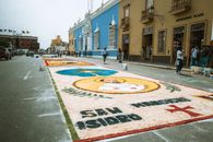 Vibrant sand art on a street in Trujillo, Peru, during a lively festival with people observing the artwork.