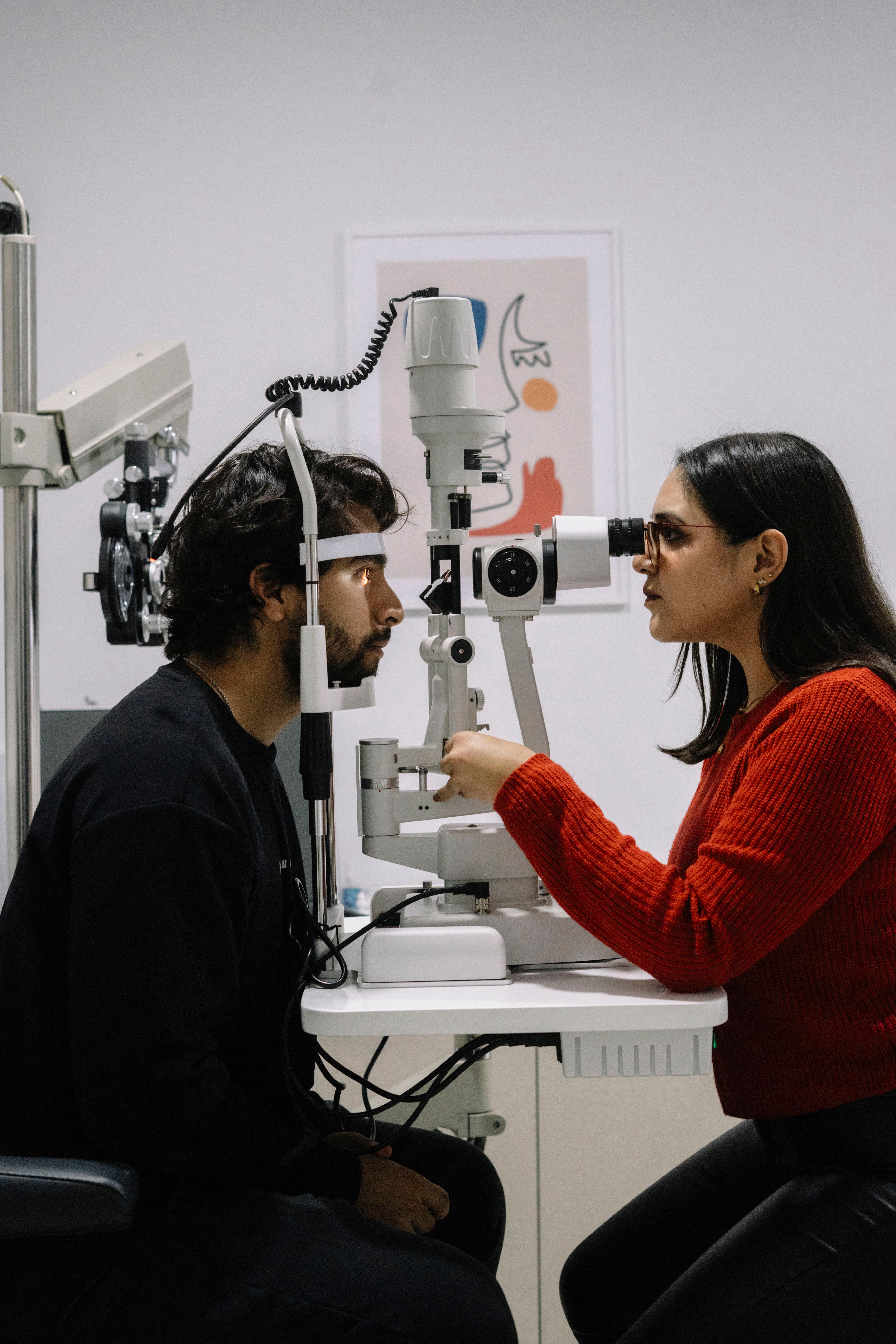 An ophthalmologist examining a patient's eyes using a slit-lamp microscope.