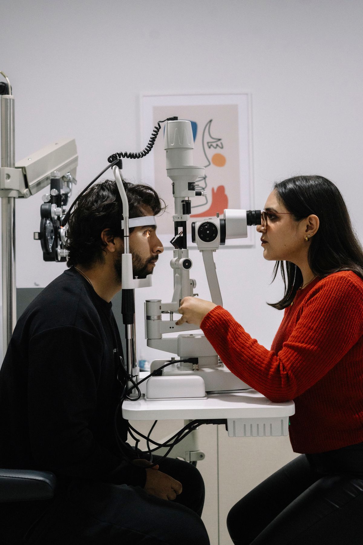 Optometrist examining a patient's eye with a slit lamp