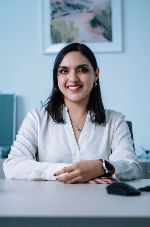 Free Confident businesswoman in white shirt smiling at her office desk, exuding professionalism and warmth. Stock Photo
