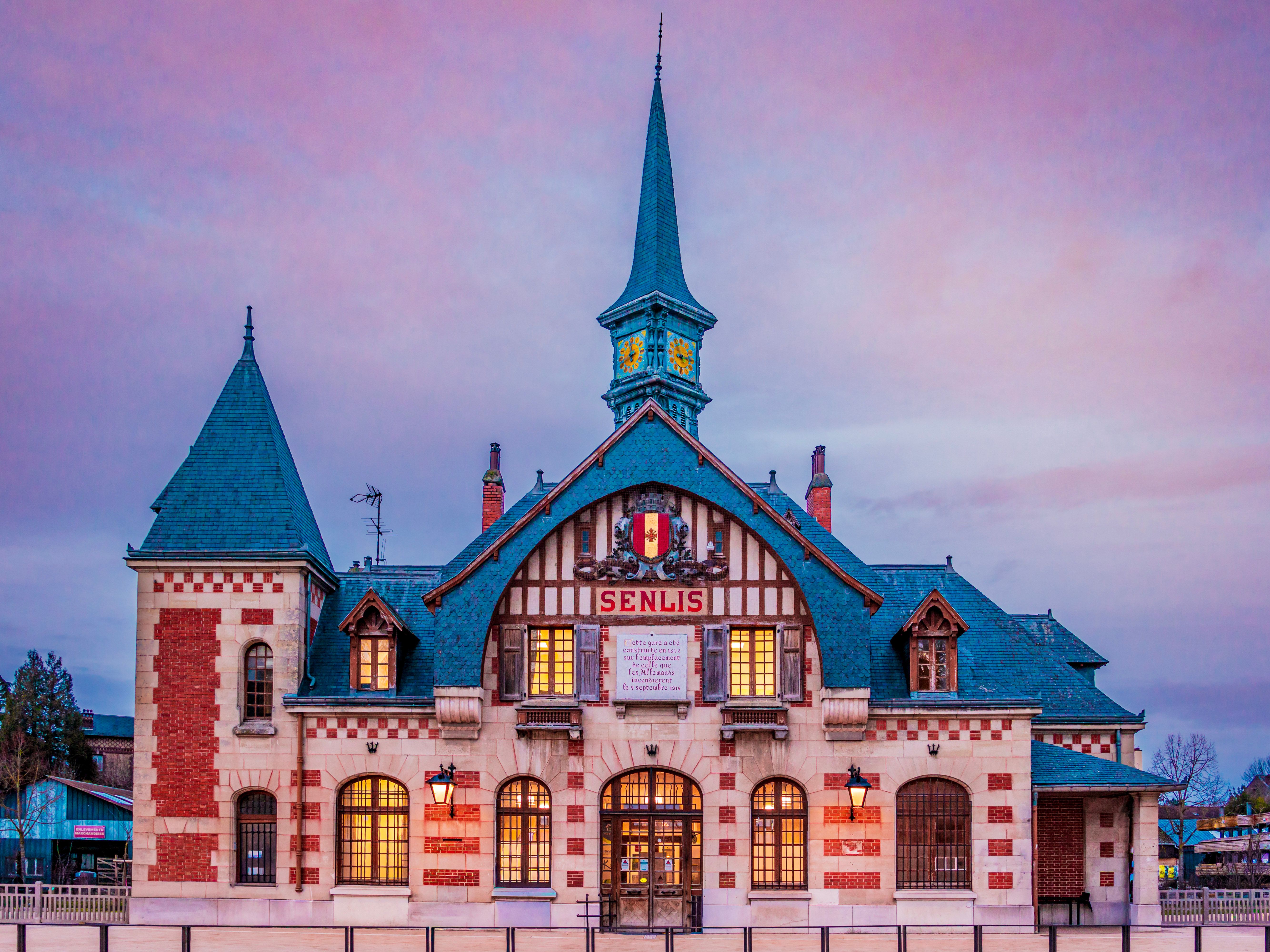 Beautiful historic building in Senlis, Hauts-de-France, during twilight with vibrant sky.