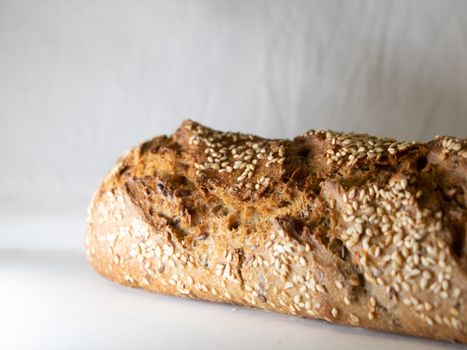 Freshly baked homemade bread loaf with sesame seeds, highlighting texture and crust.