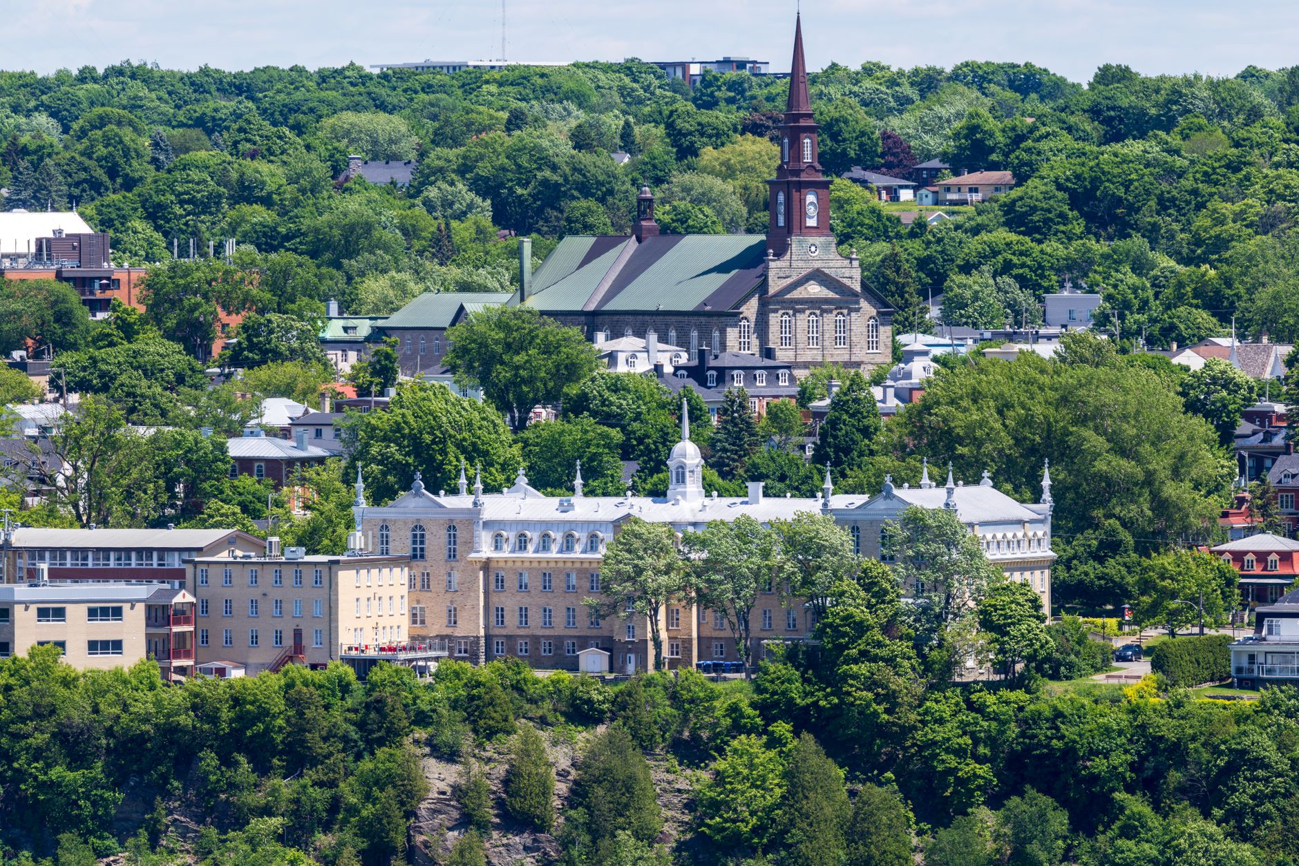 Stunning aerial view of Quebec City's historic buildings surrounded by lush greenery in summer.