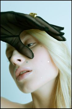 Elegant portrait of a woman with artistic makeup and black gloves.