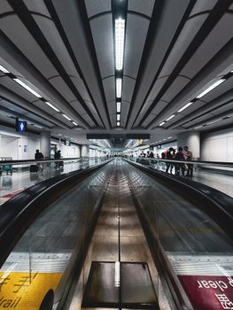 Dynamic view of a modern airport terminal walkway with travelers in China.