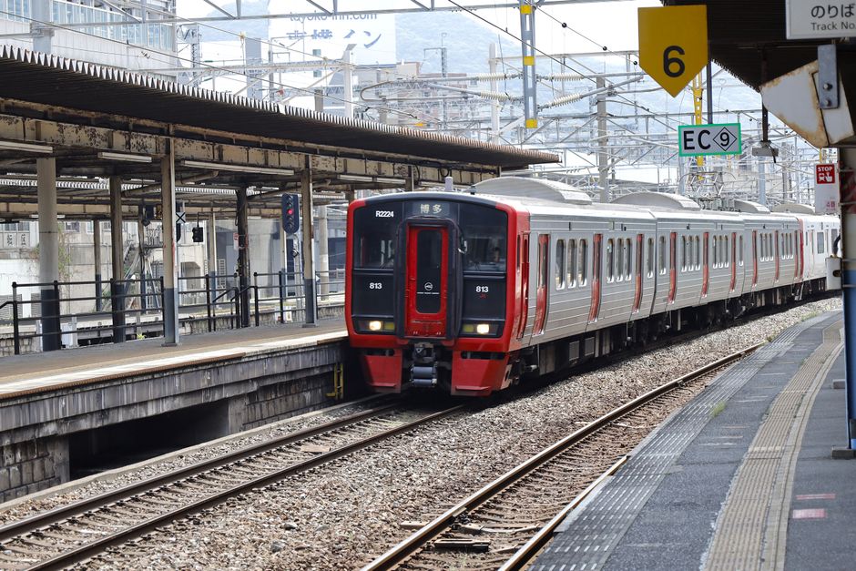 赤と銀色の通勤電車が、日本の福岡にある北九州駅に到着する。