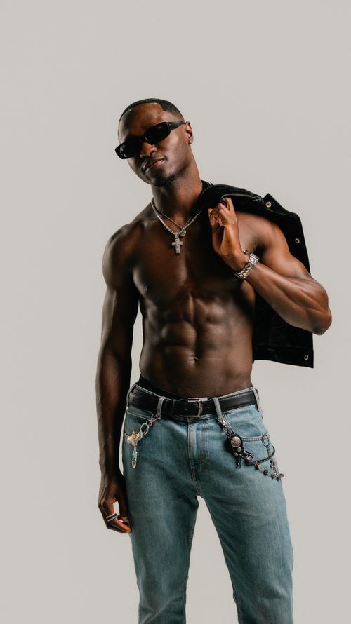 Free A confident man in sunglasses and jeans exudes style and attitude in this modern portrait. Stock Photo