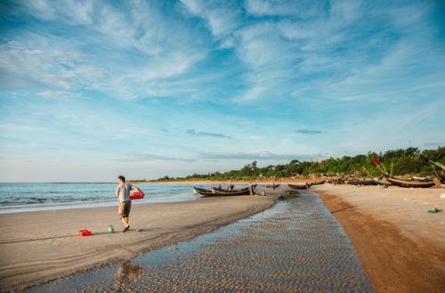 Free Peaceful Quảng Trị beach scene with fishing boats under a bright blue sky. Stock Photo
