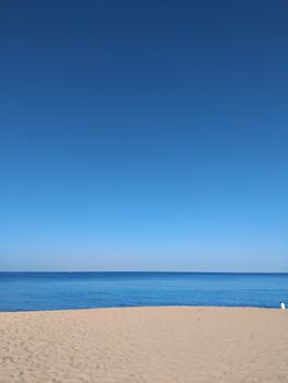 A tranquil beach scene with clear blue skies, ideal for travel and relaxation themes.