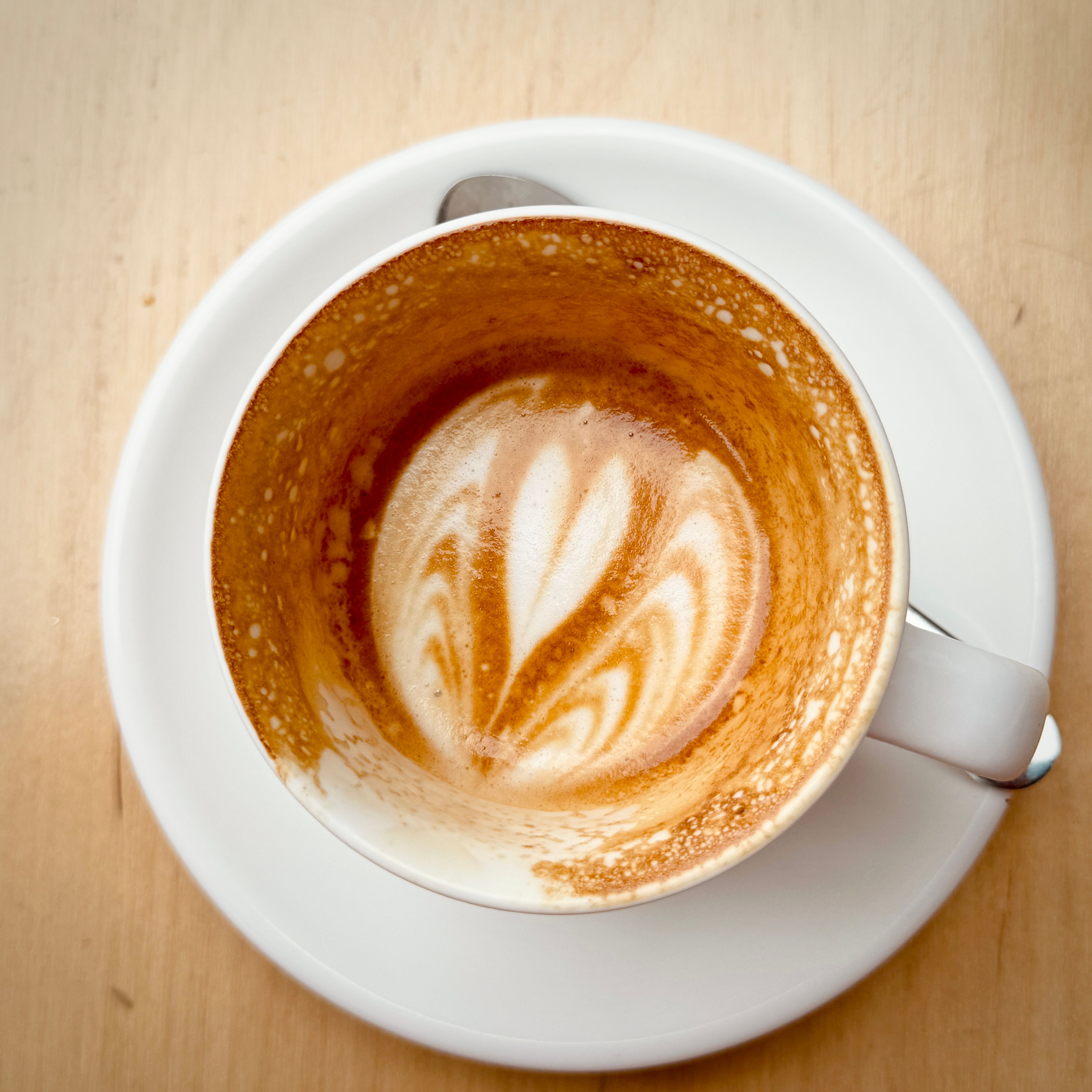 An empty coffee cup on a wooden table — photo by Jasmine Jin-Yu Lin on Pexels