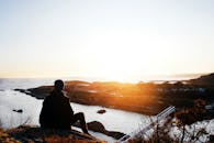 日落时分，坐在悬崖上俯瞰挪威海岸的剪影，捕捉宁静的海景