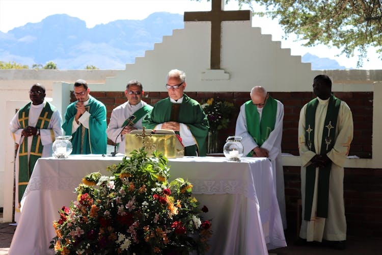 Senior Priest Reading Bible During Mass In Open Air