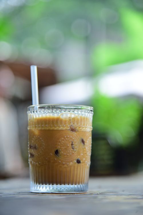 Free Close-up of iced coffee in glass with straw outdoors, perfect for summer refreshment. Stock Photo