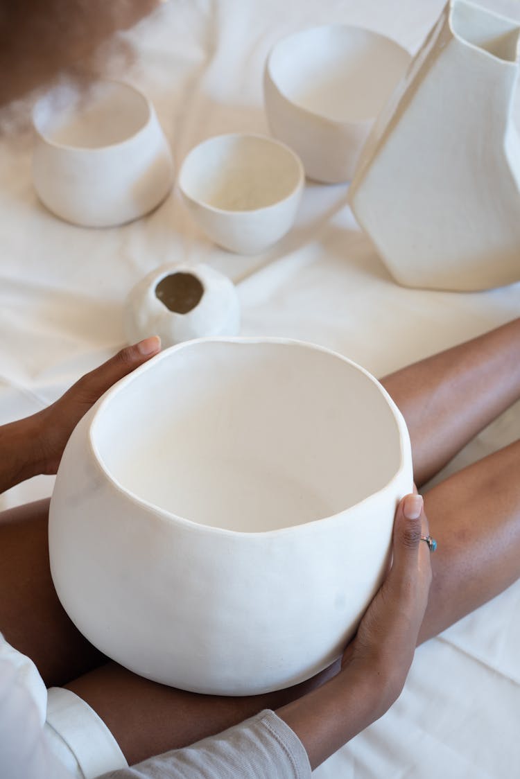 Black Craftswoman With Handmade Ceramic Bowl In Workshop