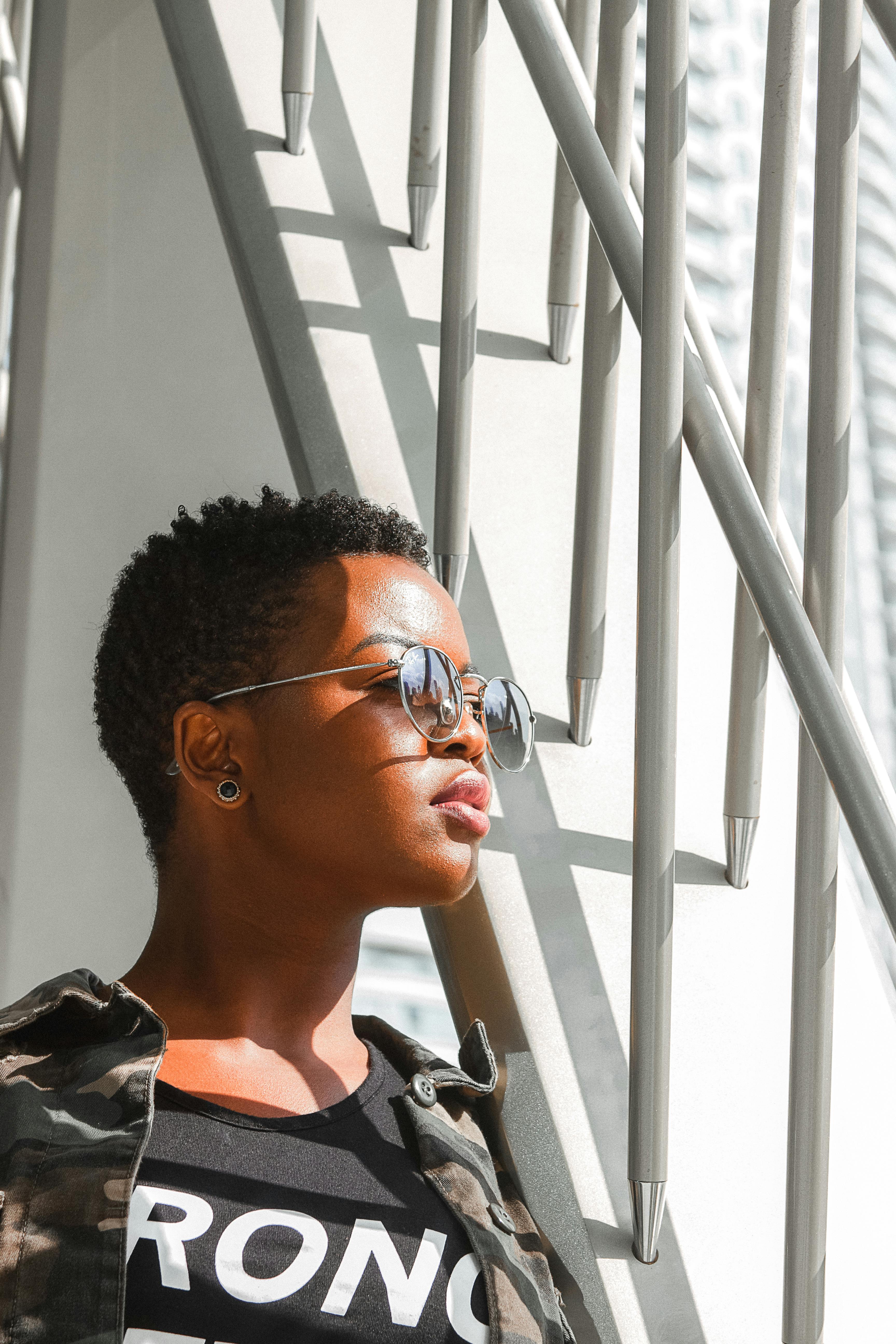 一位戴着太阳镜的女人在阳光下沉思，投下几何形状的阴影