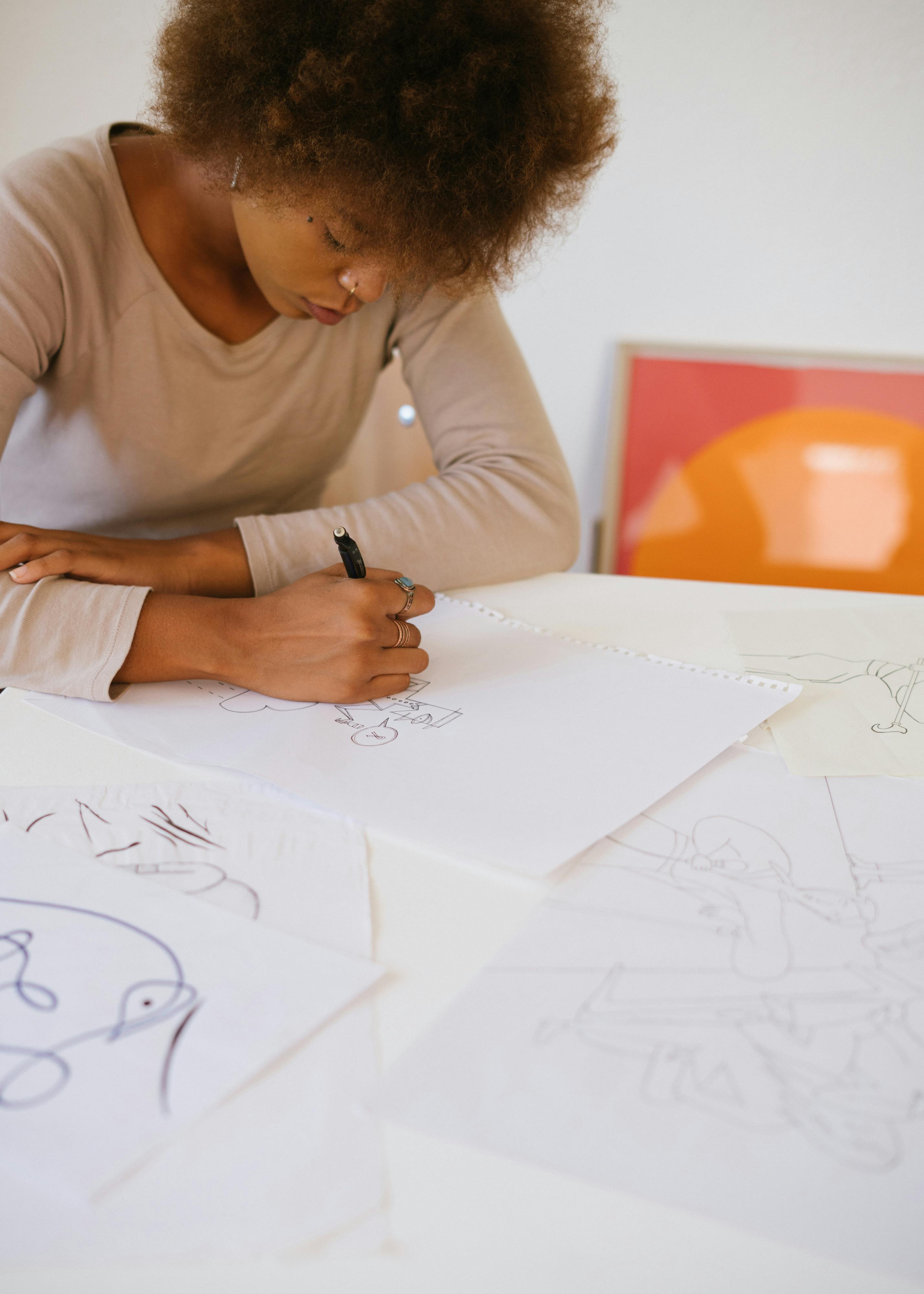 photo of woman drawing on white paper