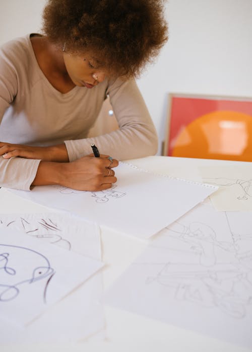 Photo of Woman Drawing on White Paper