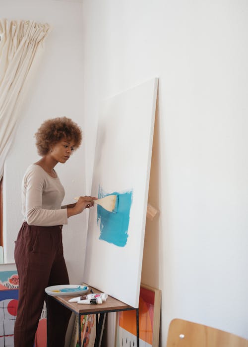 Фотография женщины, рисующей синей краской