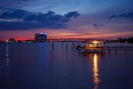 黄昏时分，港口镜头宁静，以码头和充满活力的日落倒影为特色