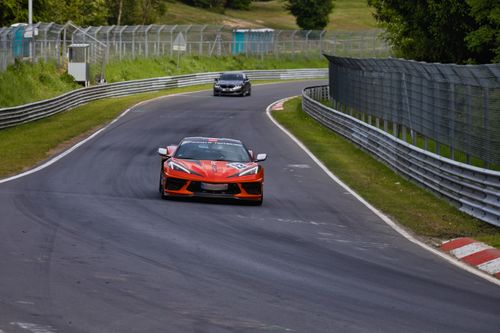 Free Dynamic car racing scene on a famous European race track amidst lush greenery. Stock Photo