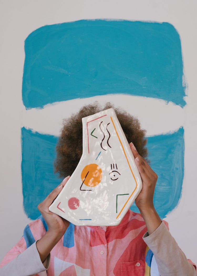 Black Female Artist With Painted Vase In Creative Room