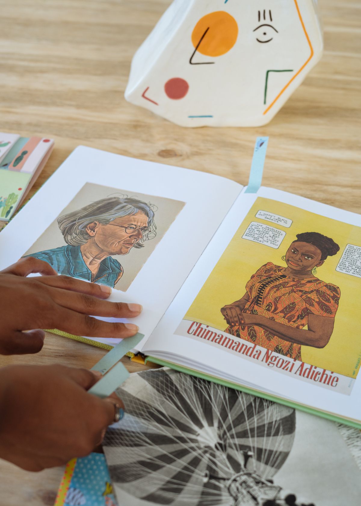 Self-taught painter explaining pigment mixing and brushwork to visitors during a community exhibition in Auzet