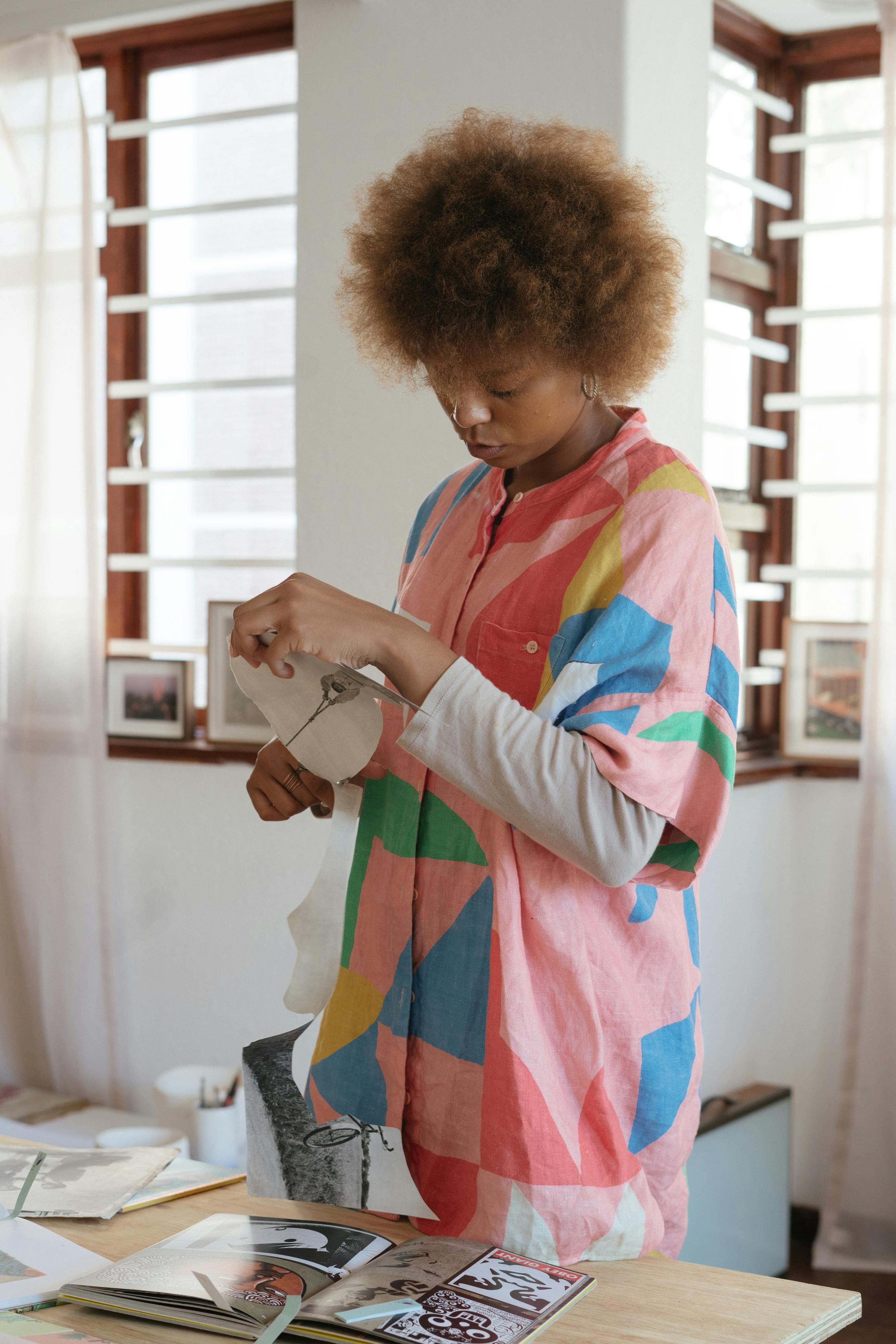 concentrated female designer preparing paper cutouts for creative project