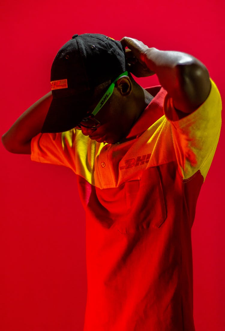 Man Dressed In DHL Clothes Posing In Red Lighting 