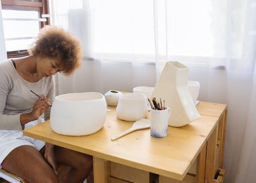 Free Focused young artist painting ceramic bowl Stock Photo