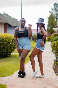 Two women enjoying a sunny day, posing confidently in casual summer attire.