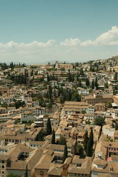 Aerial view of the historic Albayzín in Granada, Spain, showcasing picturesque architecture and lush greenery.